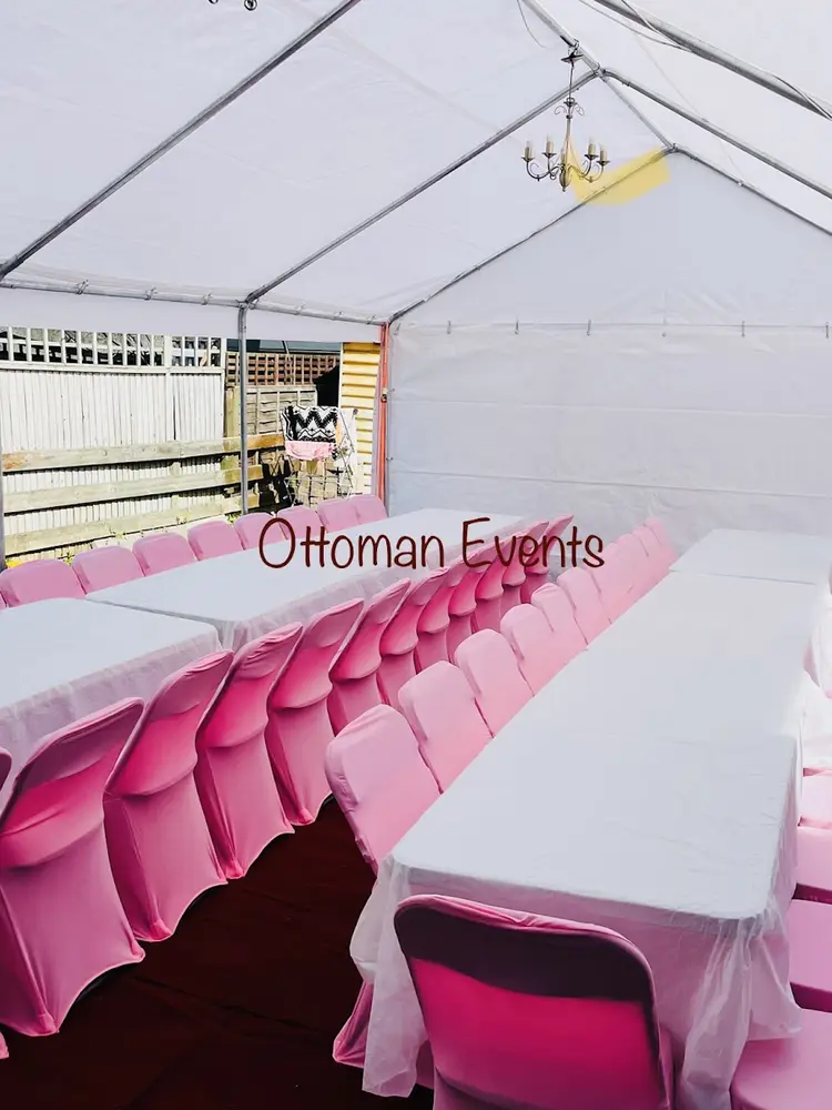 Marquee interior with rows of pink covered chairs at long white tables